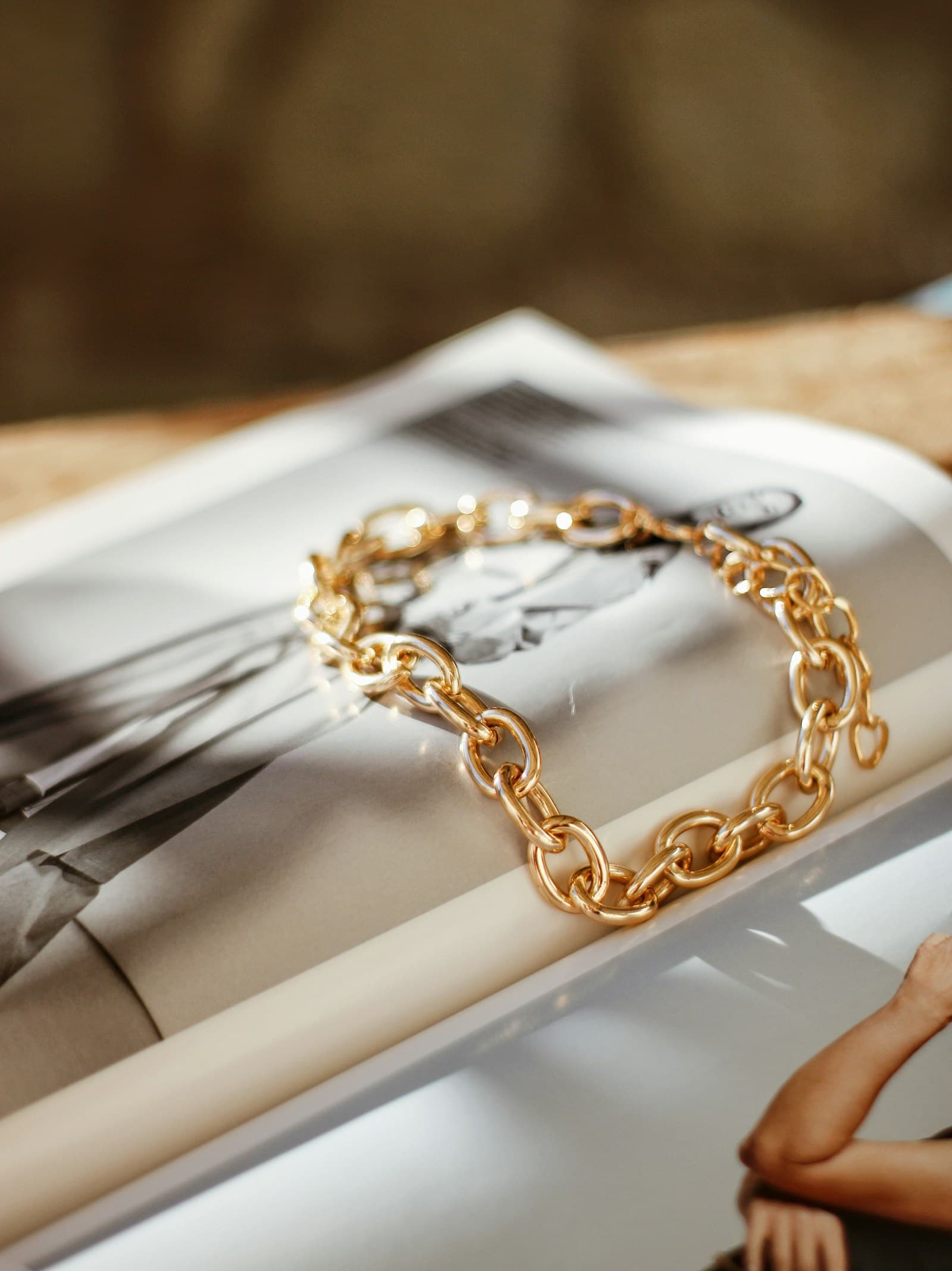 Goldenes Gliederarmband auf einem aufgeschlagenen Magazin